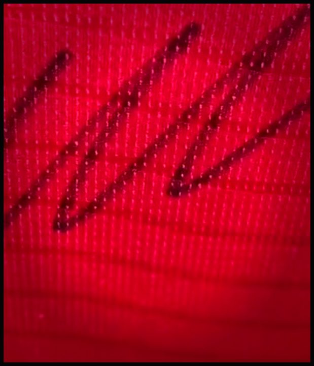 Detalle de la firma de Cristiano Ronaldo en la camiseta roja con el número 7, enmarcada en Belmourde Barbería